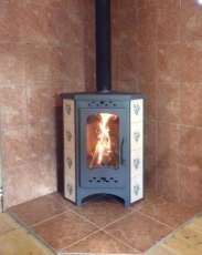 Недорогая печь-камин Бавария угловая с плитой незабудка Амазонка бай фото в интерьере в Гомеле