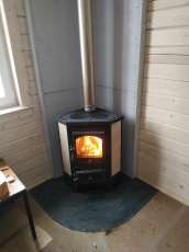 Недорогая печь-камин со стеклом Бавария угловая с плитой фото в интерьере в Гомеле